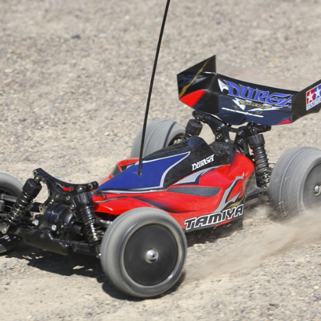 Tamiya DB01 Durga 4WD electric buggy kicking up dirt during high-speed off-road run
