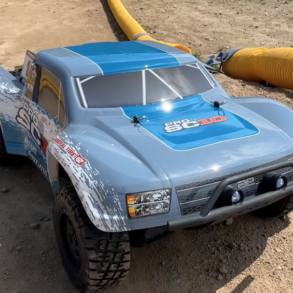 Team Associated Pro4 SC10 1/10 scale 4WD short course truck on dirt track, RTR brushless platform focused on smooth handling and stability