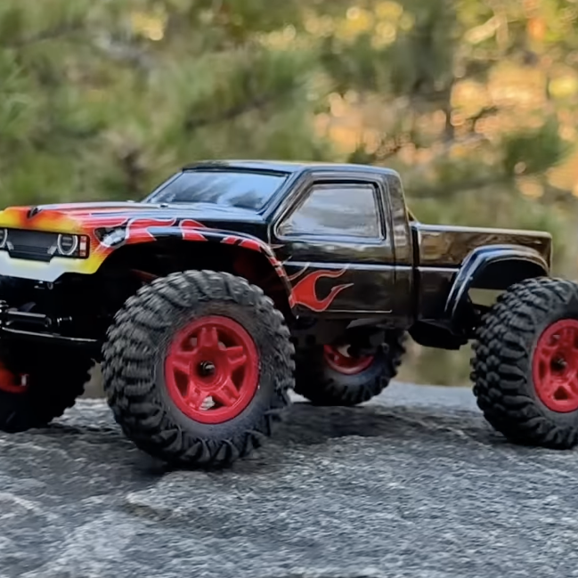 Furitek Terra COMP 1/18 brushless rock crawler with black body and red flame design climbing on rocks during outdoor test