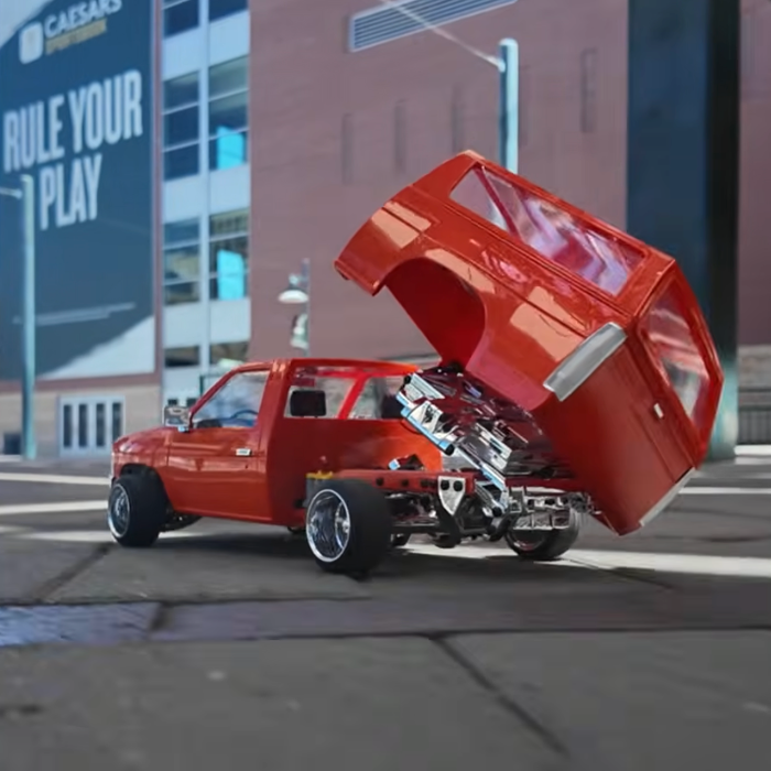 Redcat 1993 Nissan Hardbody Bed Dancer RTR mini truck with articulated bed movement driving through an urban street scene