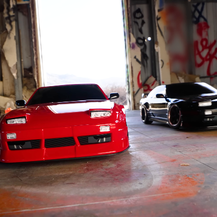 Traxxas 4 Tec Drift Nissan 240SX RC cars with red and black S13 style bodies photographed in an indoor drift setting