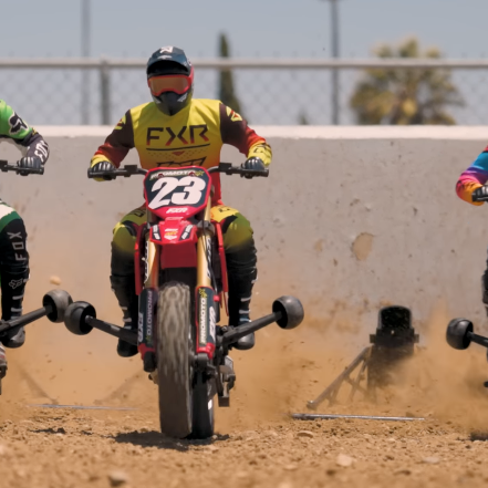 Losi Promoto MX and Promoto SM 1/4 scale RC motorcycles lineup on dirt track before race start, showing realistic riders and scale detail