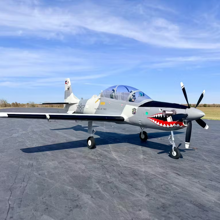 Super Tucano 1600mm RC plane ready for flight on a paved runway, highlighting retracts, flaps, and realistic turboprop-style design