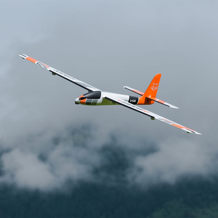 CNHL KAVAN Pulse 2200 V2 orange RC electric glider banking in flight against cloudy sky