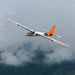 CNHL KAVAN Pulse 2200 V2 orange RC electric glider banking in flight against cloudy sky