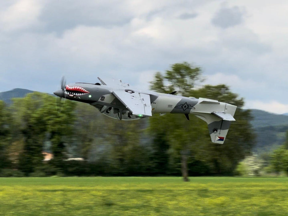 CNHL Super Tucano RC plane performing a dramatic inverted low pass with scale shark-mouth livery and LED lights visible.