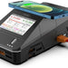 ToolkitRC Q6AC LiPo battery charger in use showing charging status on LCD screen, XT60 connection, and wireless phone charging